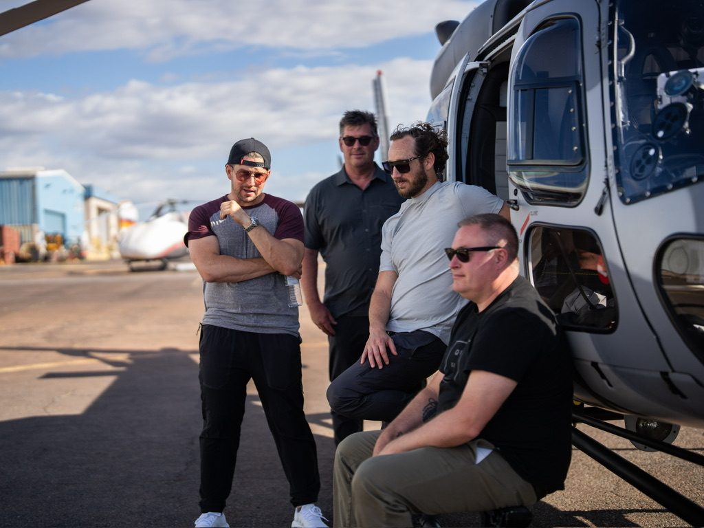 With the crew beside a helicopter