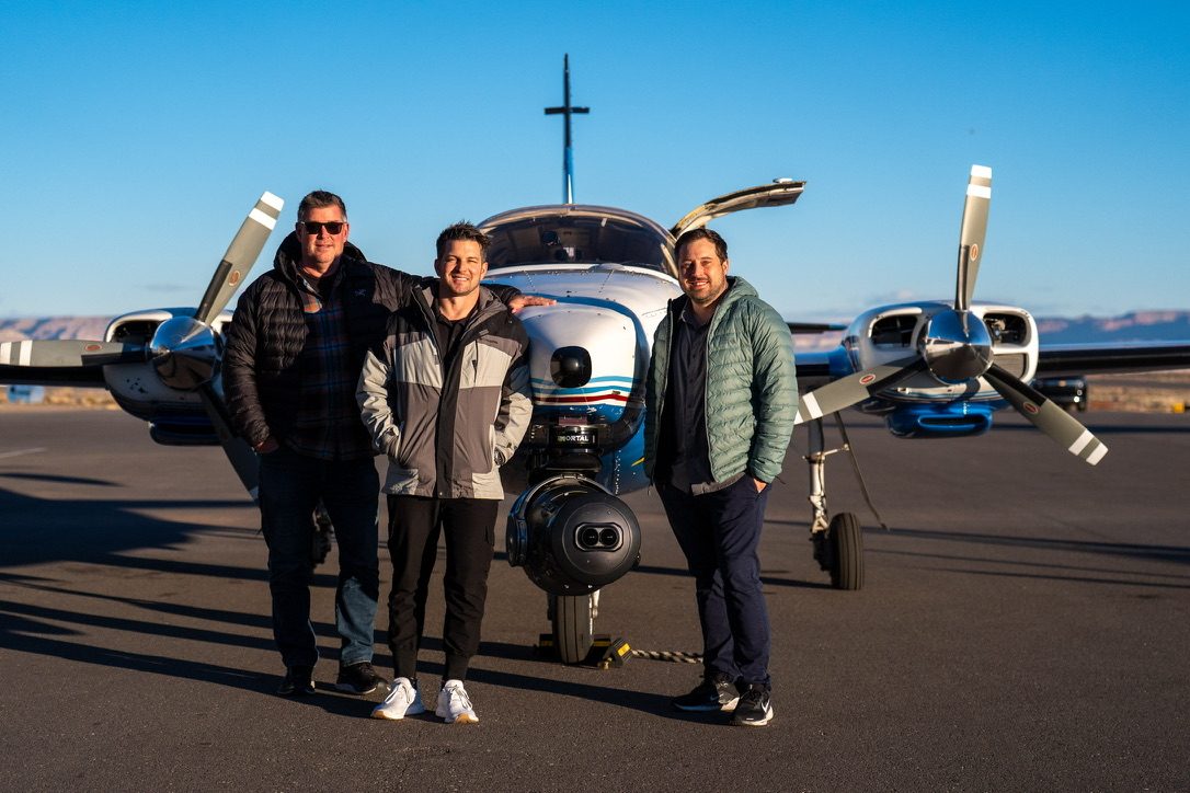 With the team beside a camera plane