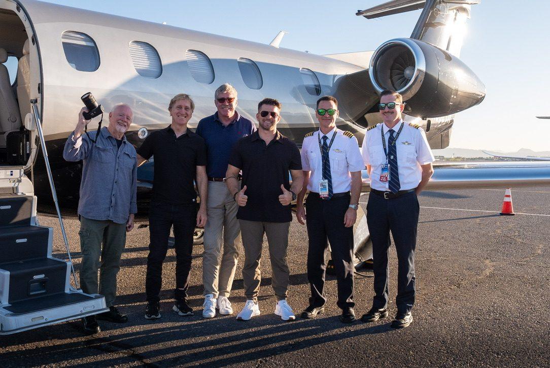 Crew lined up beside a business jet on the ramp
