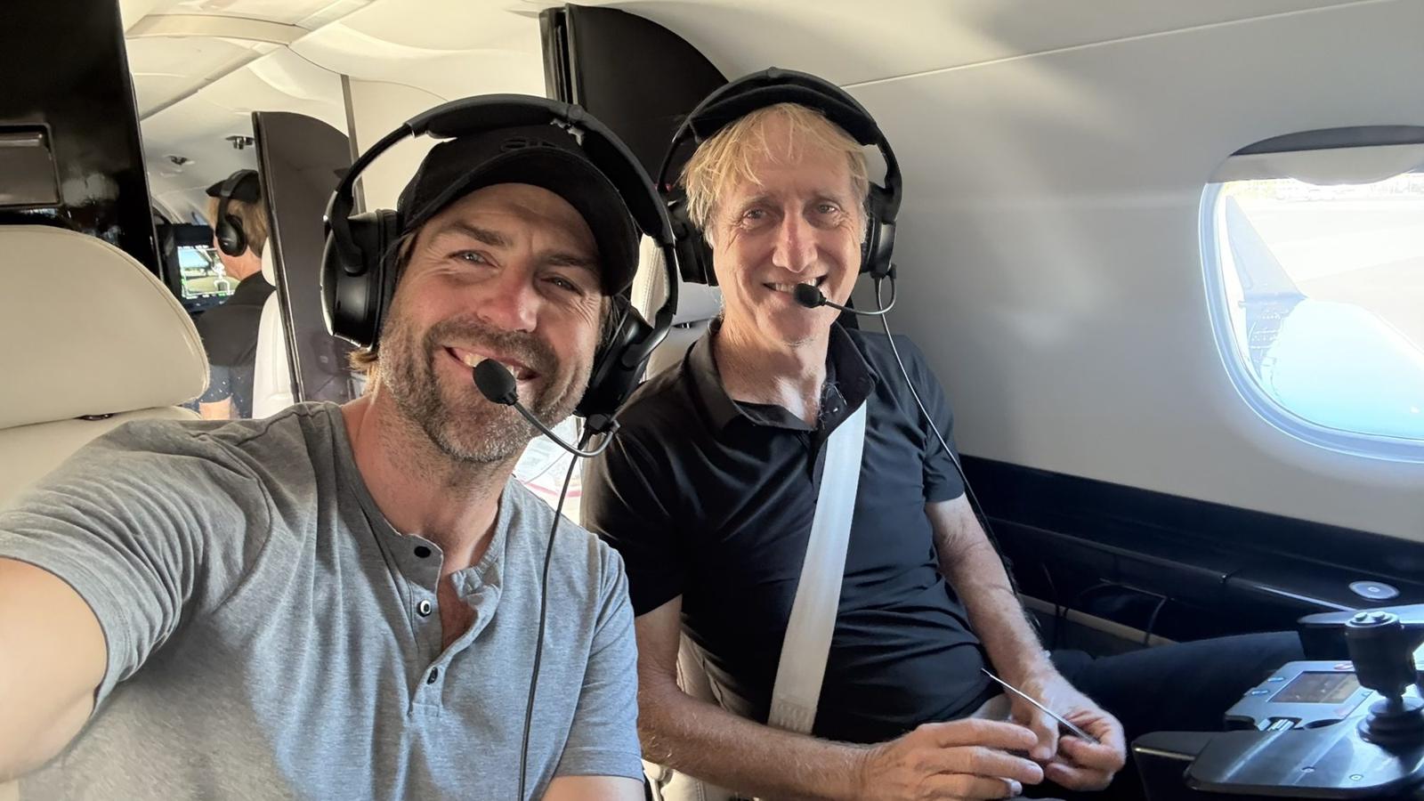 Roger Tonry with a fellow pilot in a jet cockpit, both wearing headsets