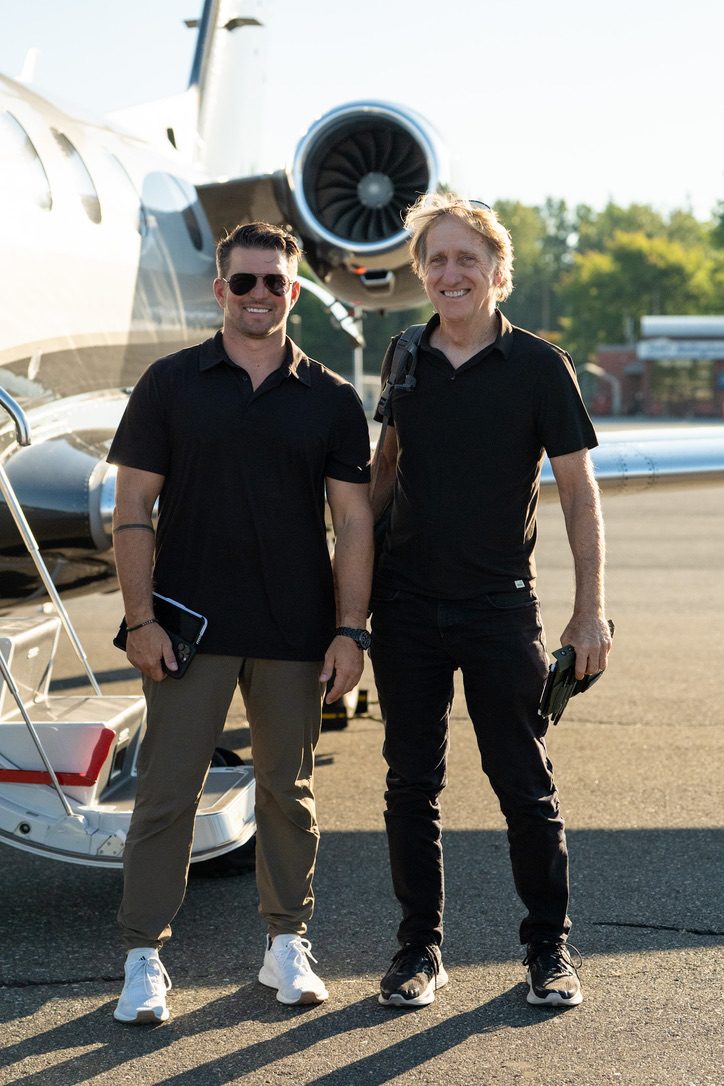 Two crew members on the ramp beside a jet